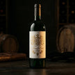Luxury custom estate textured paper roll labels applied to a dark glass wine bottle, featuring intricate 3D embossed gold foil.