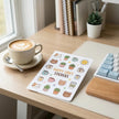Custom white vinyl sticker sheets resting on a modern desk, featuring colorful kiss-cut illustrations for retail and artists.