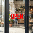 Double sided UV decal applied to a glass cafe door, showing a vibrant red OPEN sign that is 100% opaque with a 5-layer blockout printing technology.