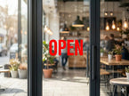 Double sided UV decal applied to a glass cafe door, showing a vibrant red OPEN sign that is 100% opaque with a 5-layer blockout printing technology.
