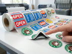 Double sided UV DTF decals gang sheet roll on a white surface, showcasing multiple 5-layer blockout window stickers printed on a transparent transfer film with a glossy finish, demonstrating 100% opacity.